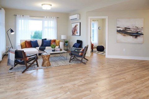 a living room with a couch and chairs and a wooden floor